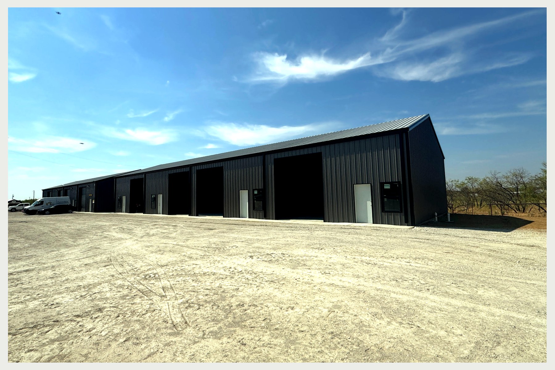Completed Building 4 at 1385 Business Park with black insulated overhead doors and crushed concrete drive area
